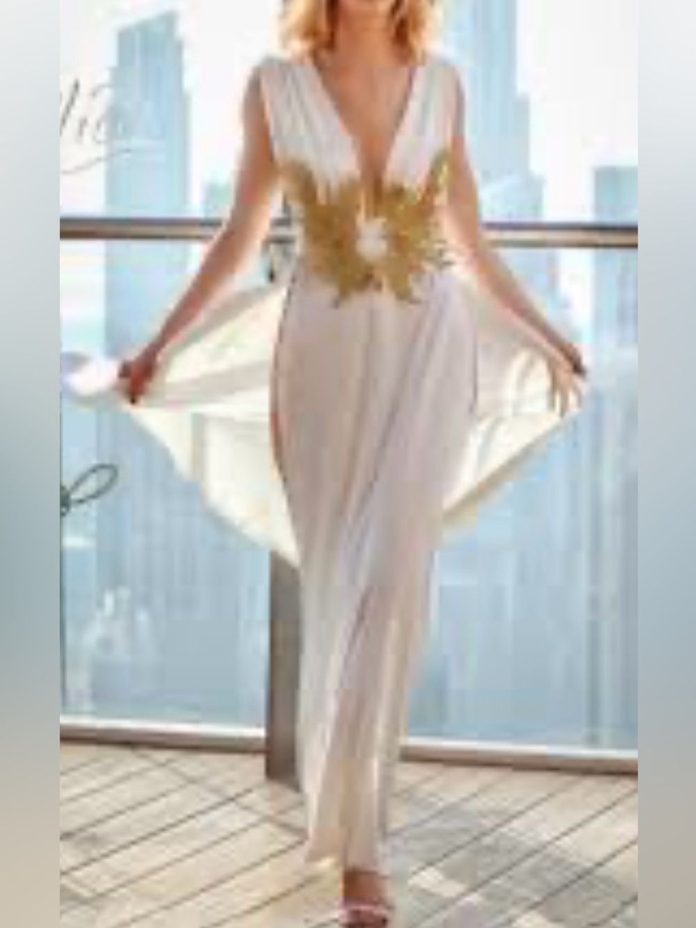 white sleeveless maxi dress featuring a plunging V-neckline adorned with ornate